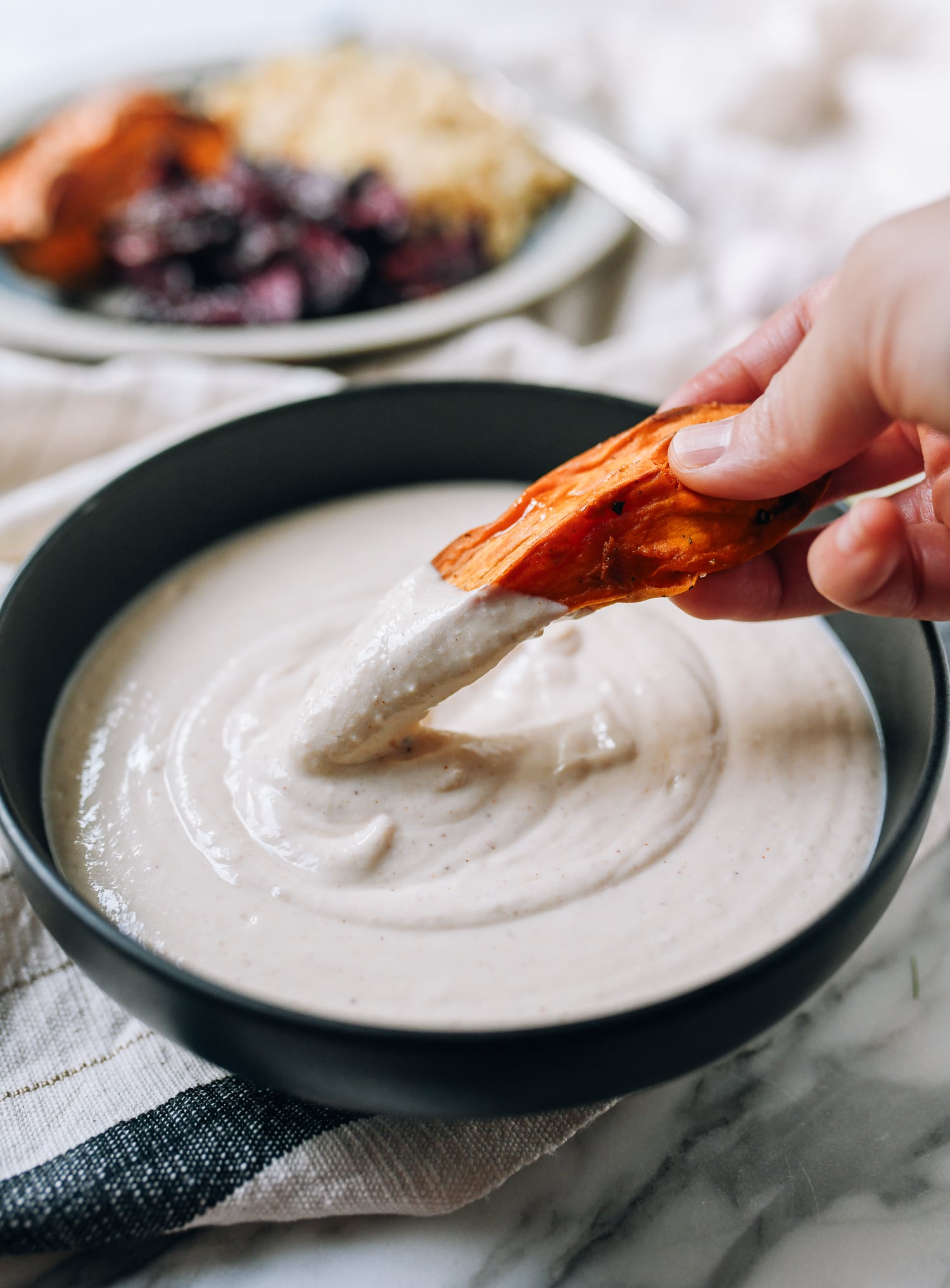 Dipping roasted sweet potato in tofu garlic aioli, thewoksoflife.com