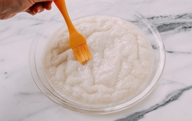 Brushing white sugar sponge cake with oil, thewoksoflife.com