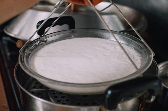 Placing dish of bai tang gao batter in steamer, thewoksoflife.com