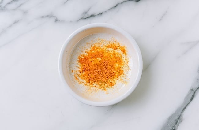 ground turmeric powder in white dish