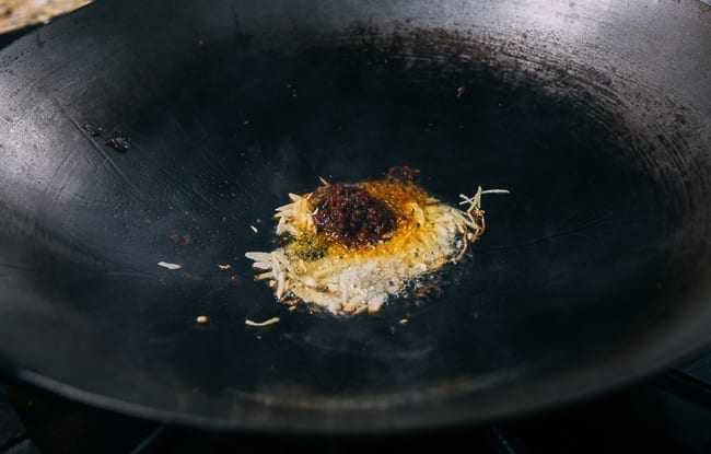 Adding belacan sauce to ginger and garlic