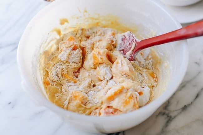 Folding flour, peaches, and nuts into batter, thewoksoflife.com