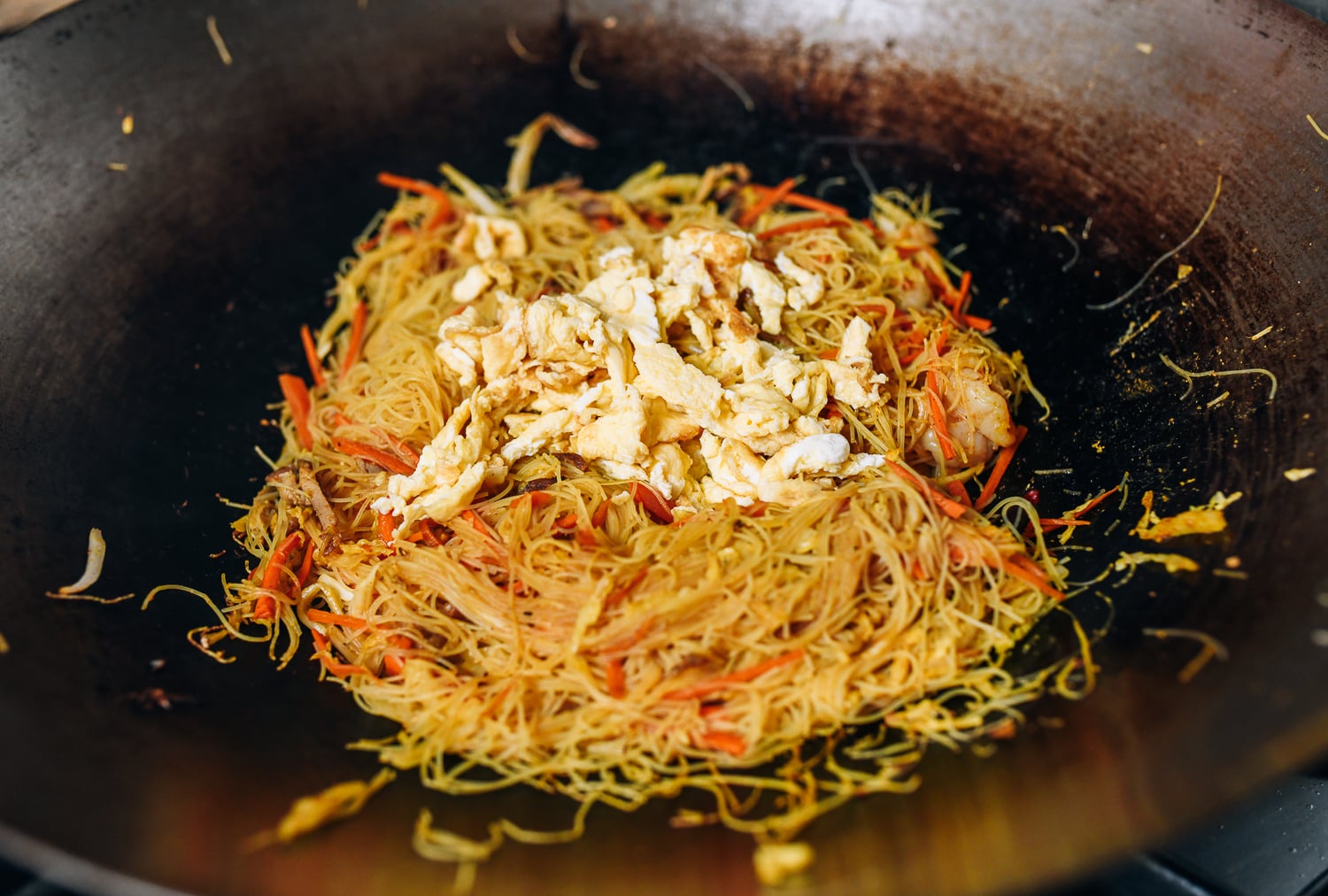 Adding cooked egg back to noodles in the wok, thewoksoflife.com