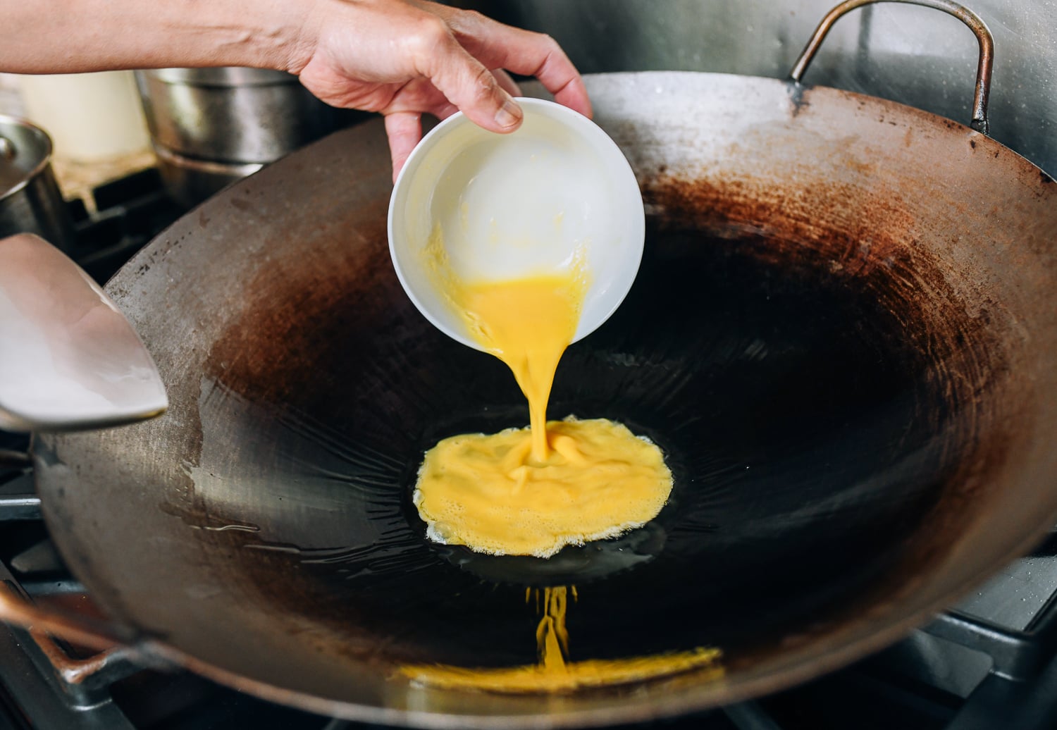Adding beaten eggs to hot wok, thewoksoflife.com