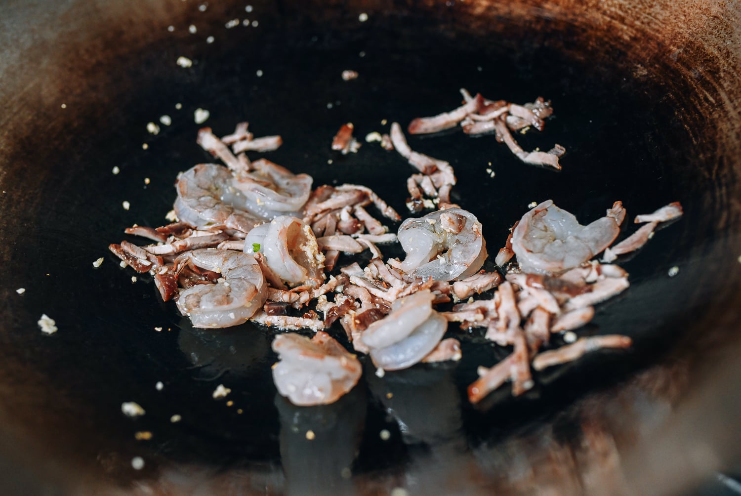 Adding shrimp and roast pork to wok, thewoksoflife.com