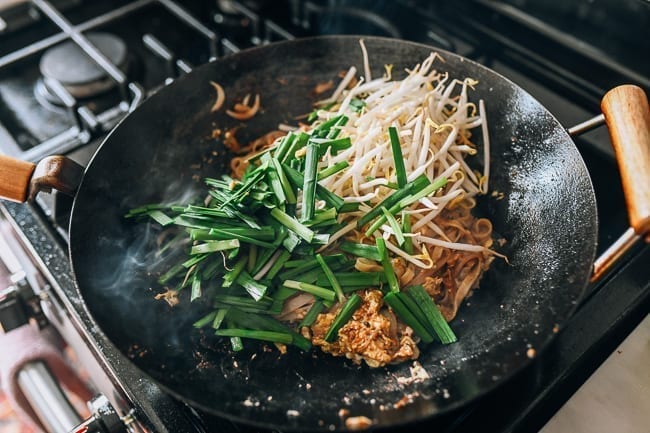 Adding garlic chives and bean sprouts to wok, thewoksoflife.com