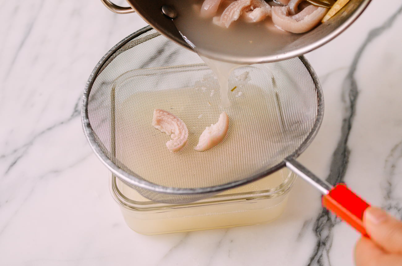 Straining pork stock into container, thewoksoflife.com