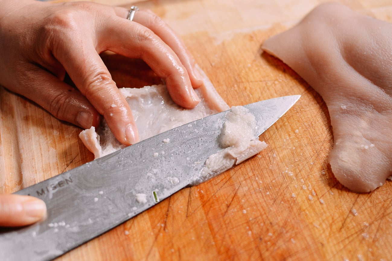 Scraping fat off of blanched pork skin, thewoksoflife.com