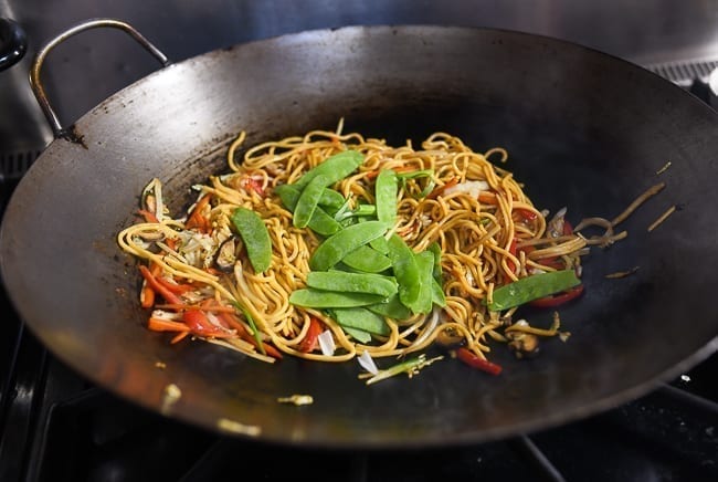Adding snow peas to lo mein, thewoksoflife.com