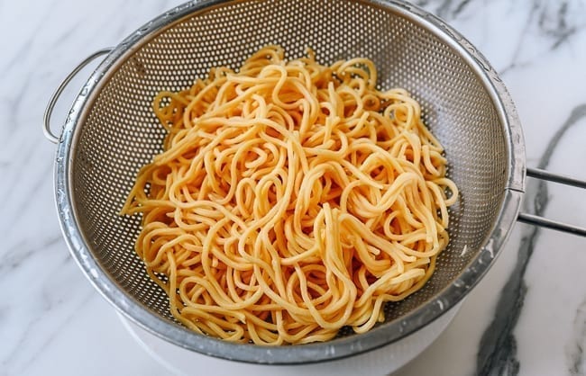 Lo mein noodles in a colander, thewoksoflife.com