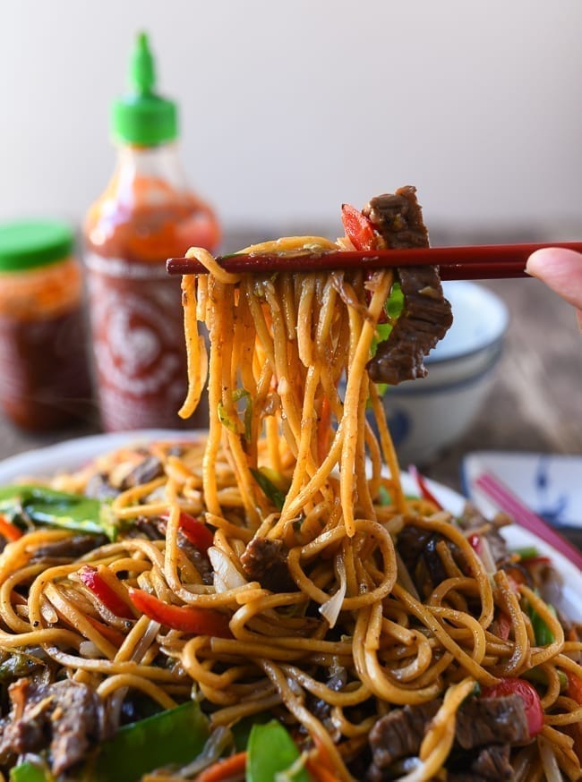 Picking up beef lo mein with chopsticks, thewoksoflife.com