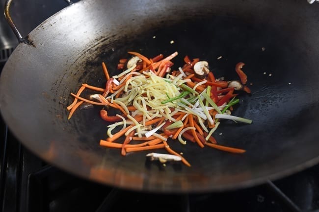 Adding bamboo shoots and white parts of scallions to wok, thewoksoflife.com