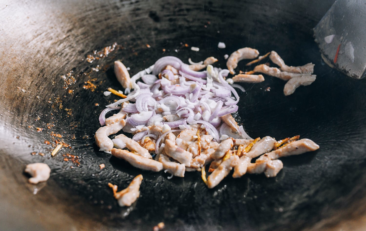 Adding shallots to chicken and ginger, thewoksoflife.com