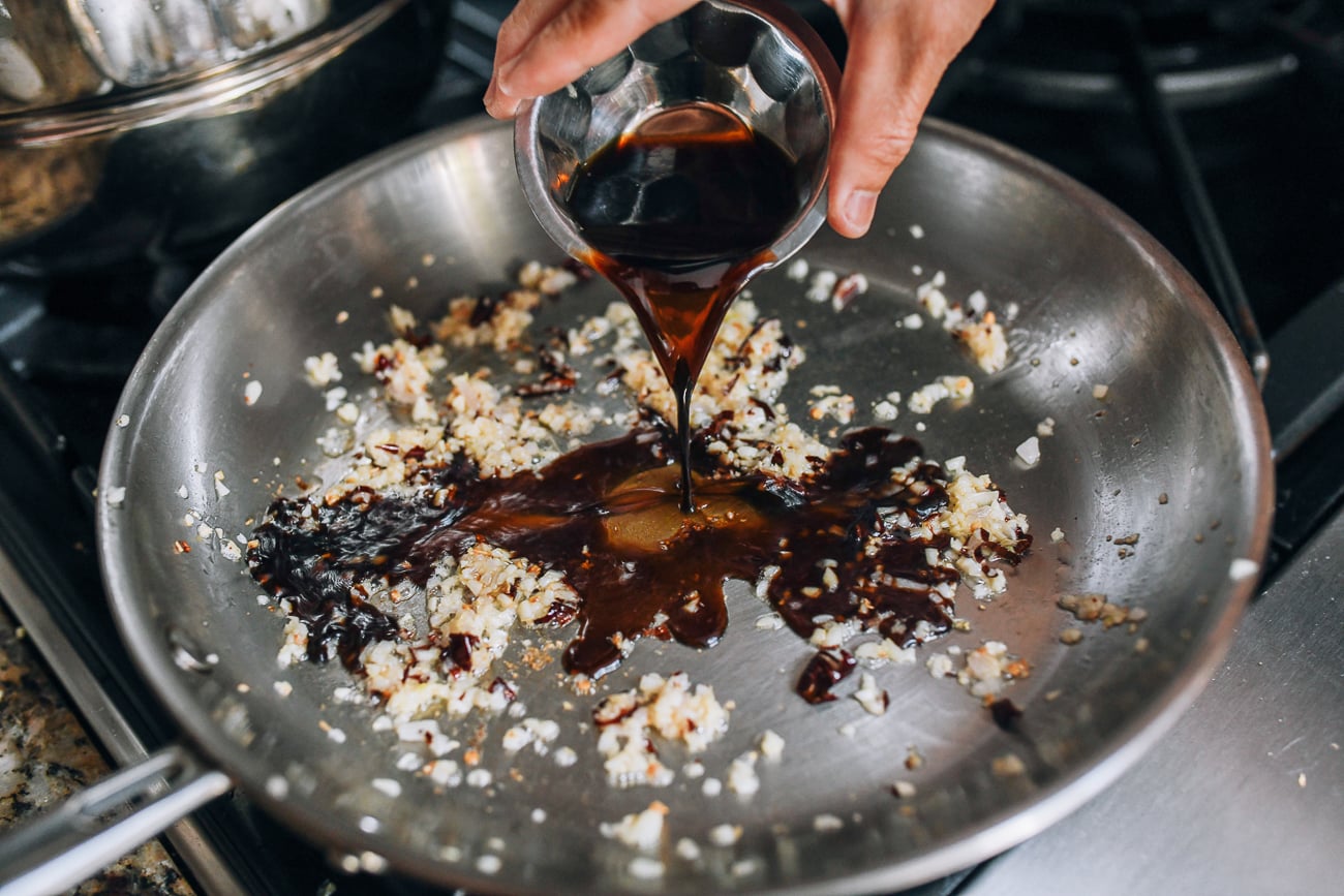 Adding soy sauce to pan
