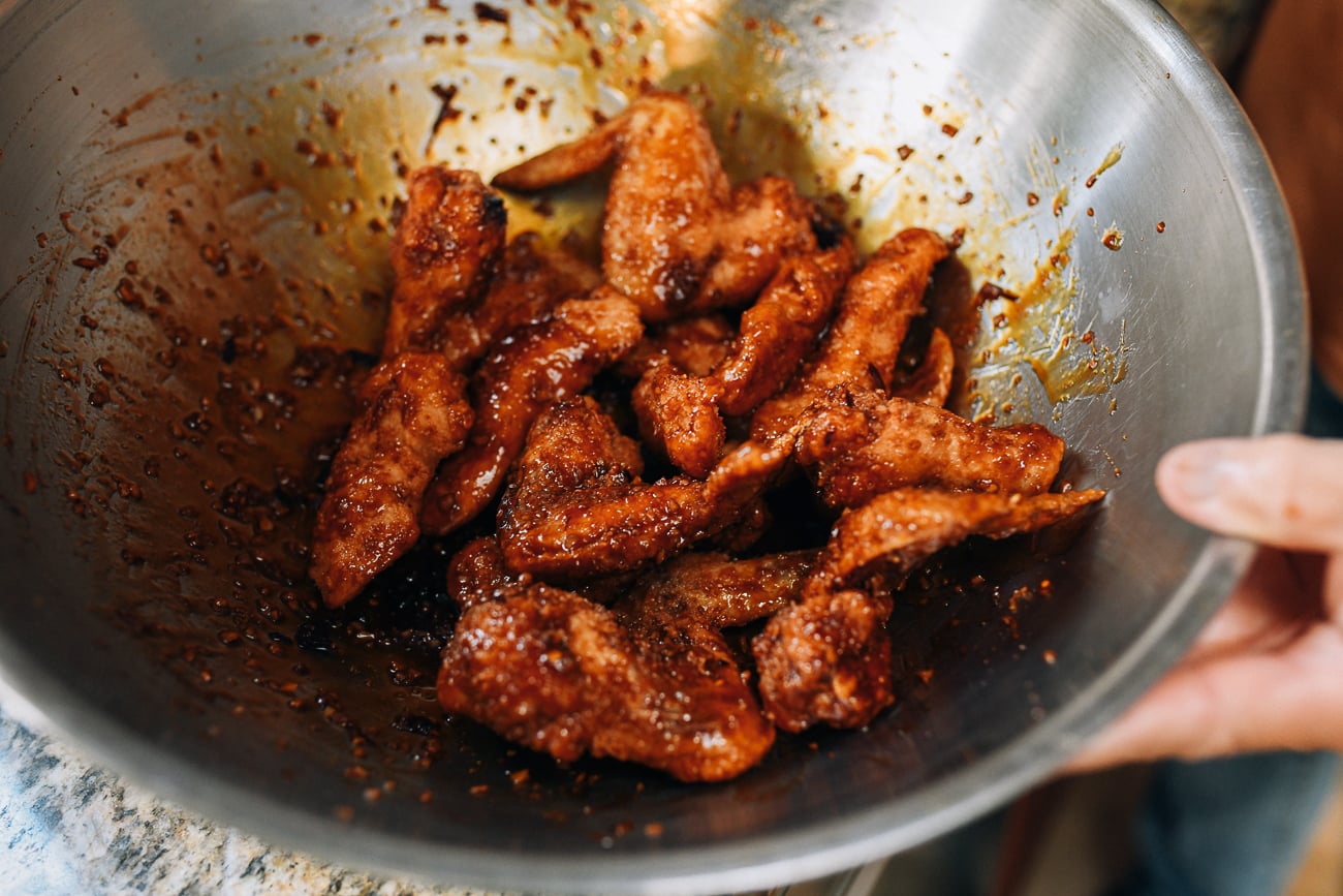 Tossing chicken in soy garlic sauce
