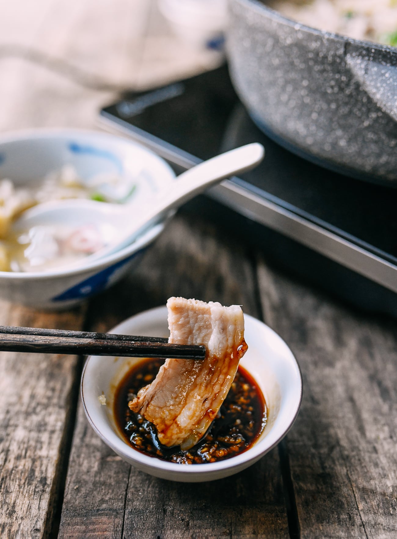 Dipping pork belly into garlic soy dipping sauce