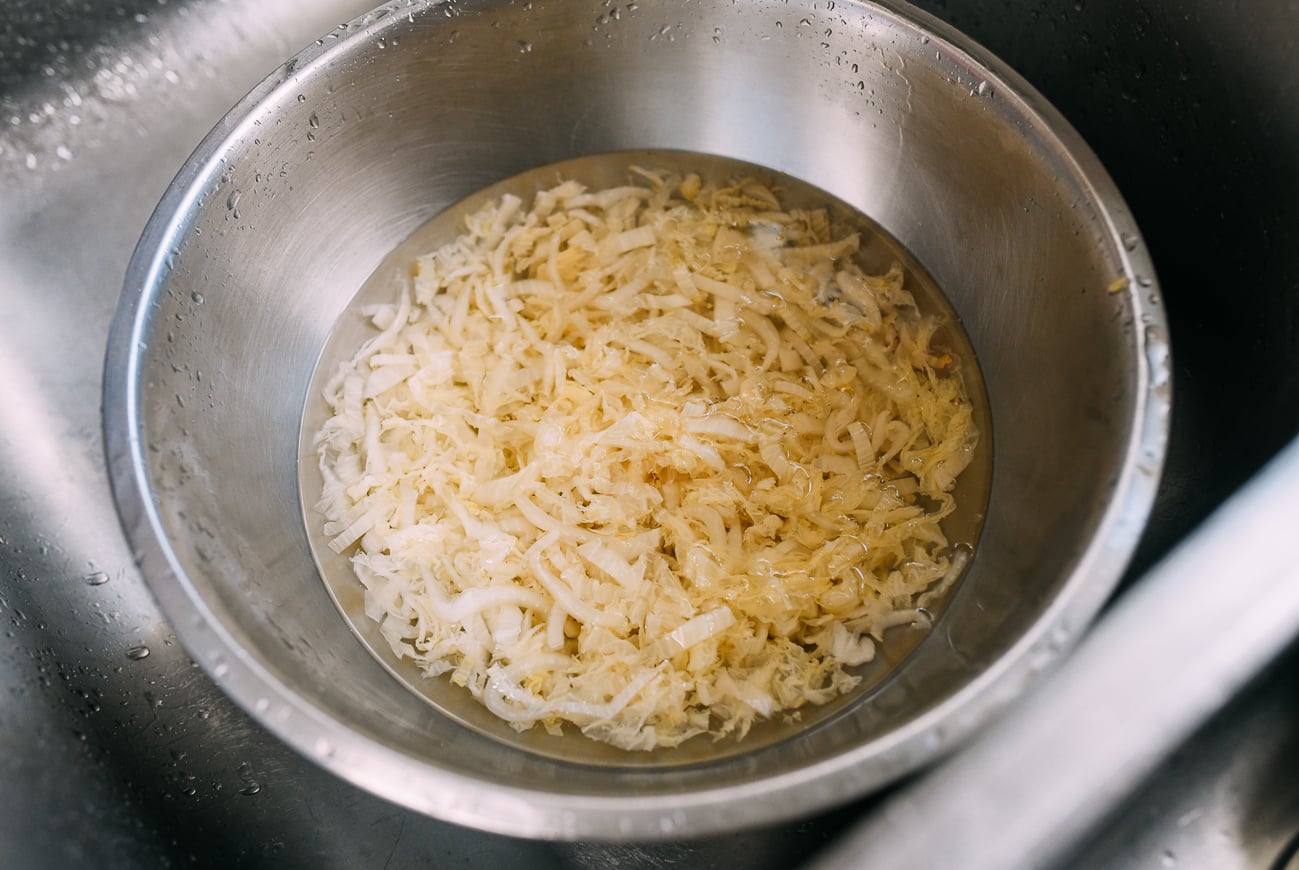 Slice sour cabbage in bowl of water