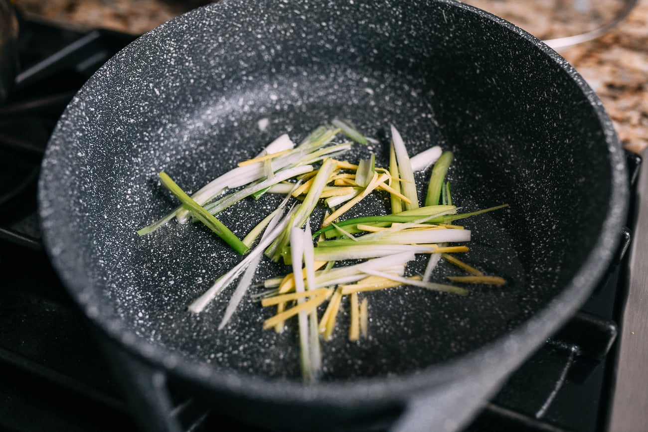 Julienened ginger and scallion whites in pot
