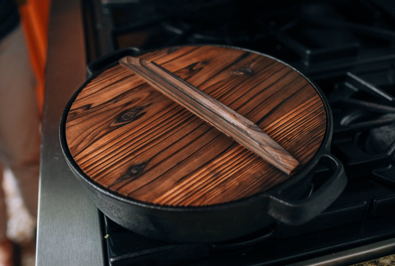 Chinese-style cast iron pan covered with wooden lid, thewoksoflife.com