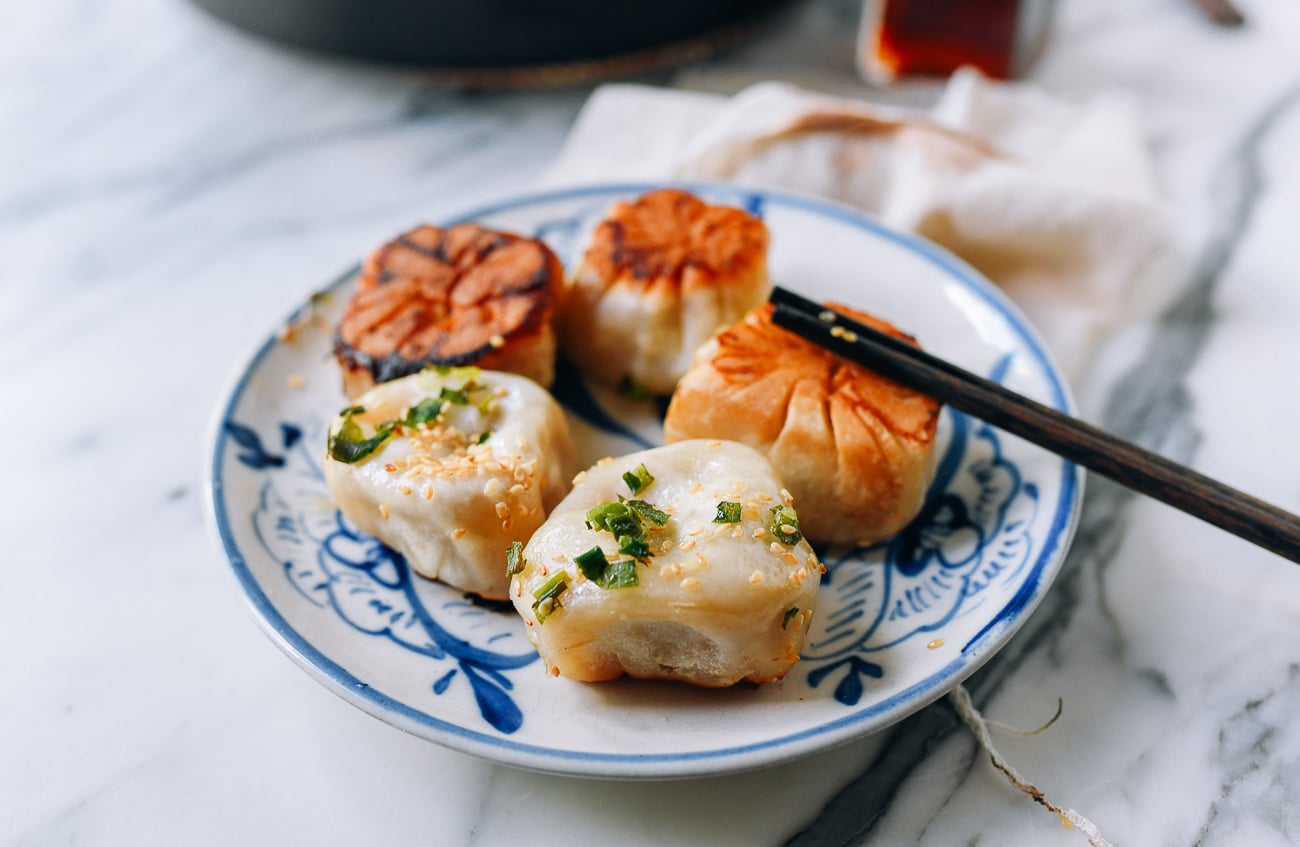 Plate of golden brown shengjian bao, thewoksoflife.com