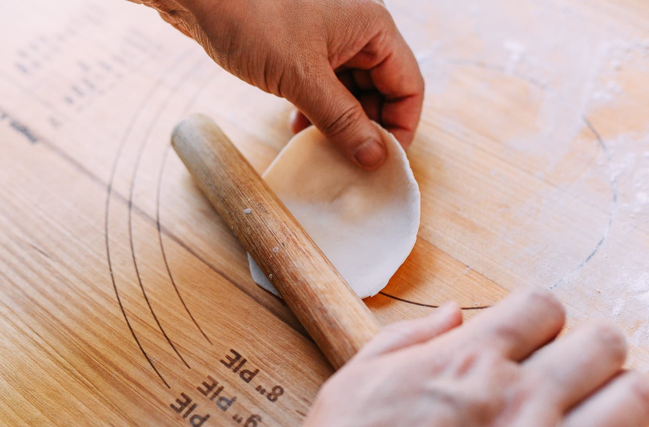 Rolling shengjian bao dough into round circles using a Chinese rolling pin, thewoksoflife.com
