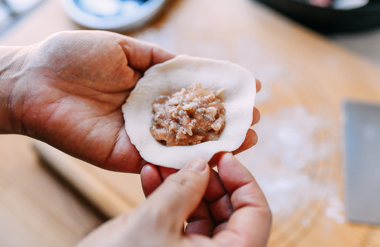 2 tablespoons of shengjian bao filling in center of rolled dough, thewoksoflife.com