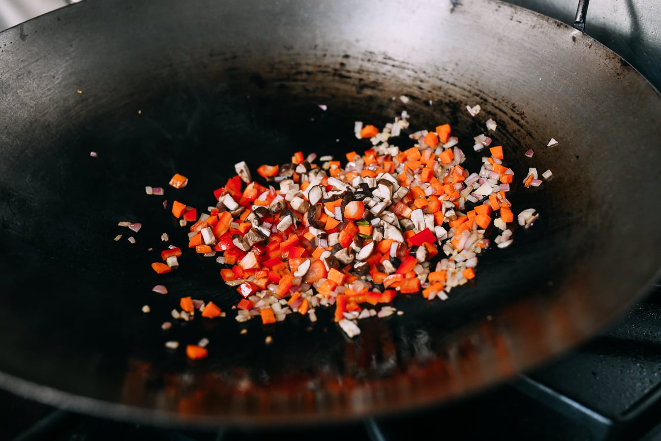 Mushrooms, bell pepper, onion, garlic, and carrots in wok