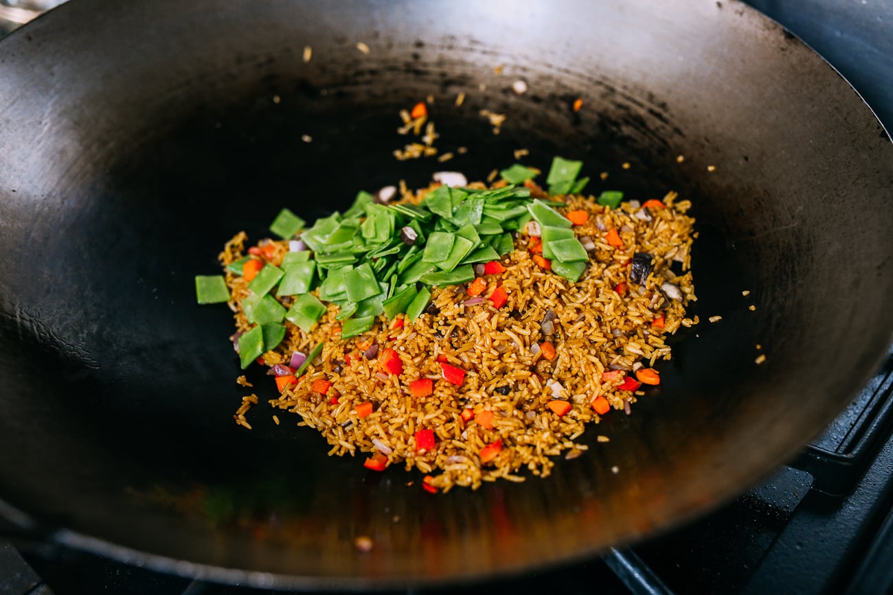 Adding snow peas to fried rice
