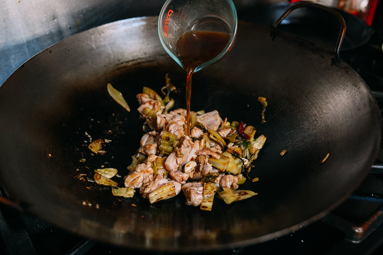 Adding sauce mixture to chicken and mustard greens