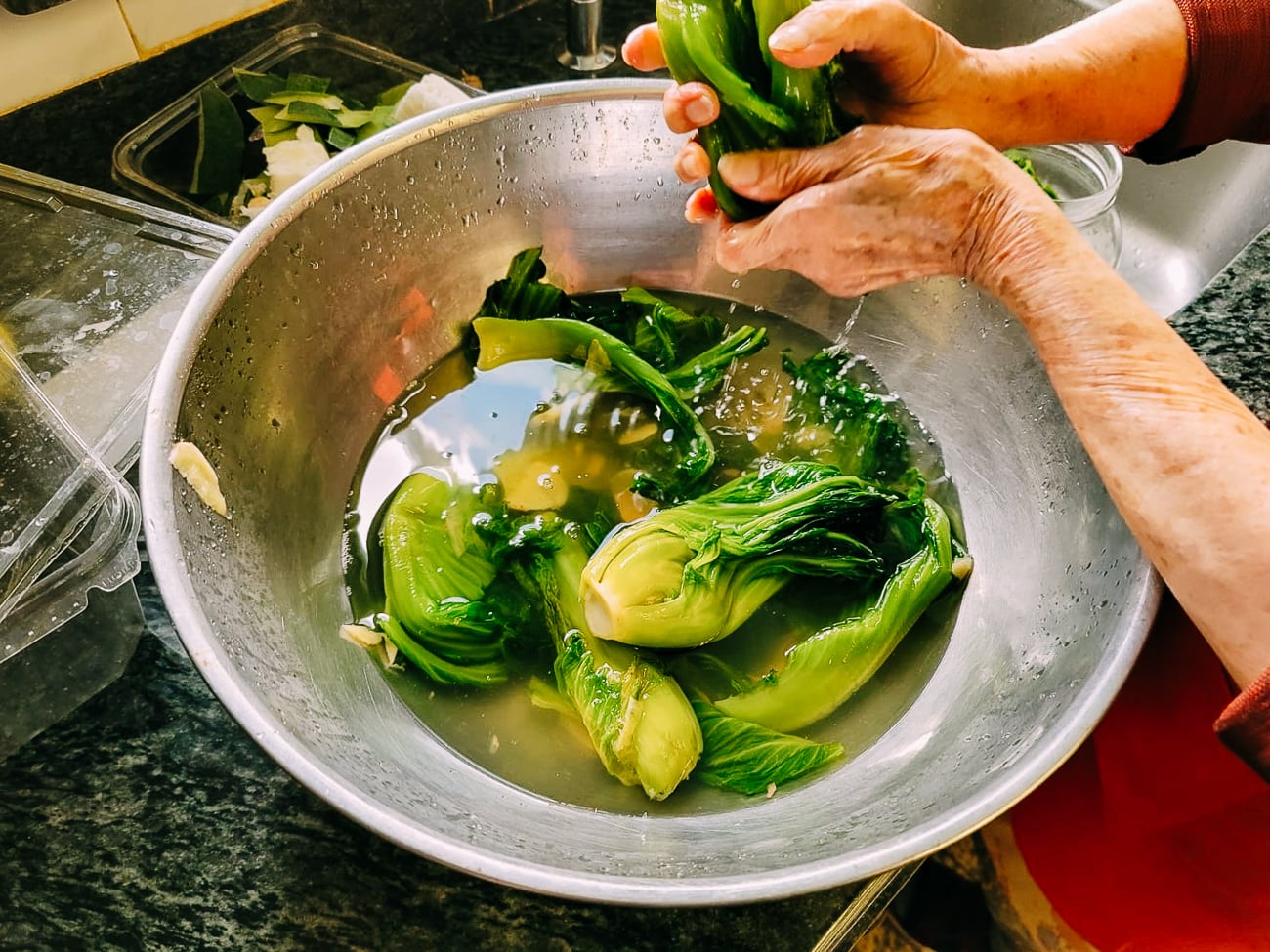 Grandma squeezing brined mustard greens