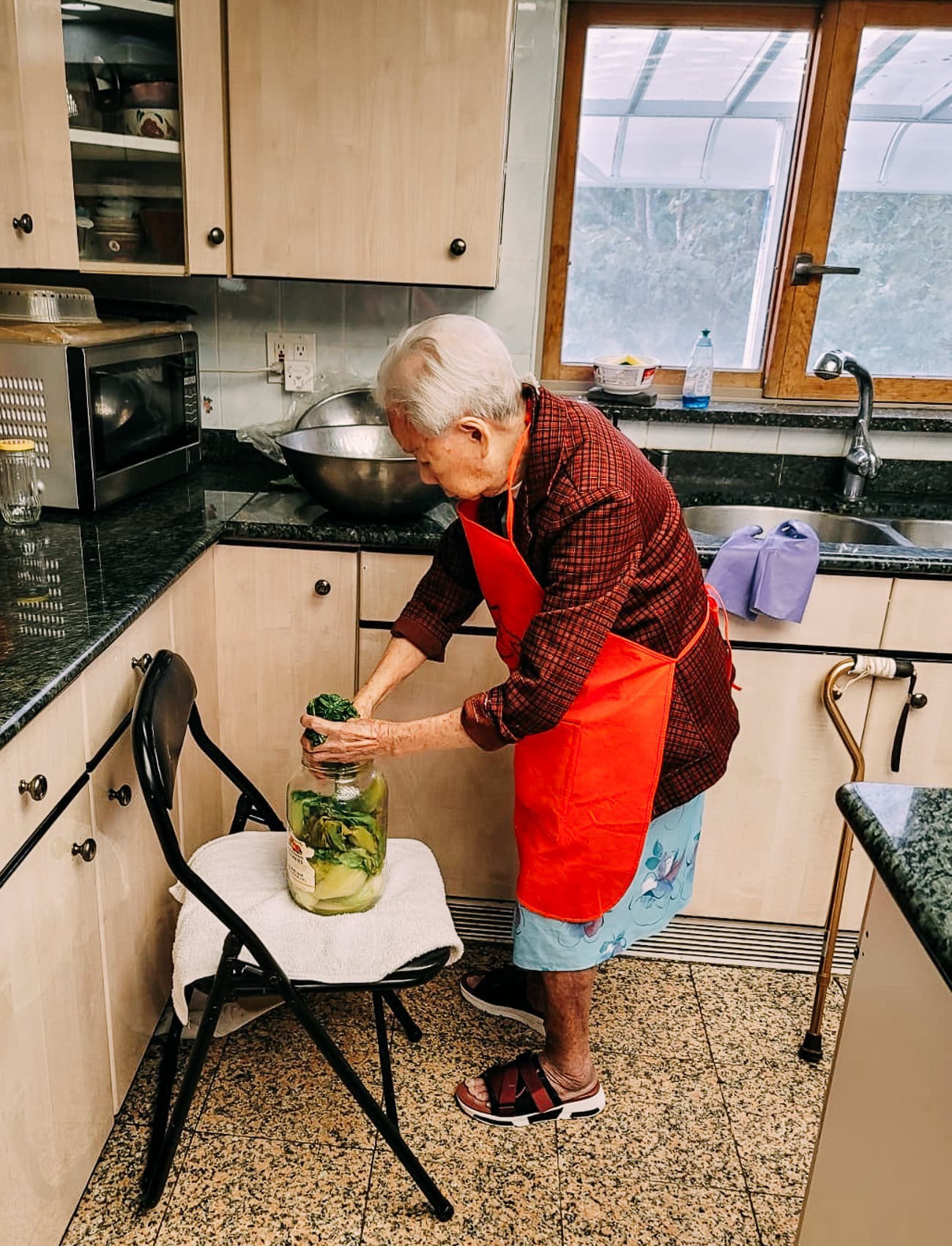 Bill's grandma putting mustard greens into pickling jar