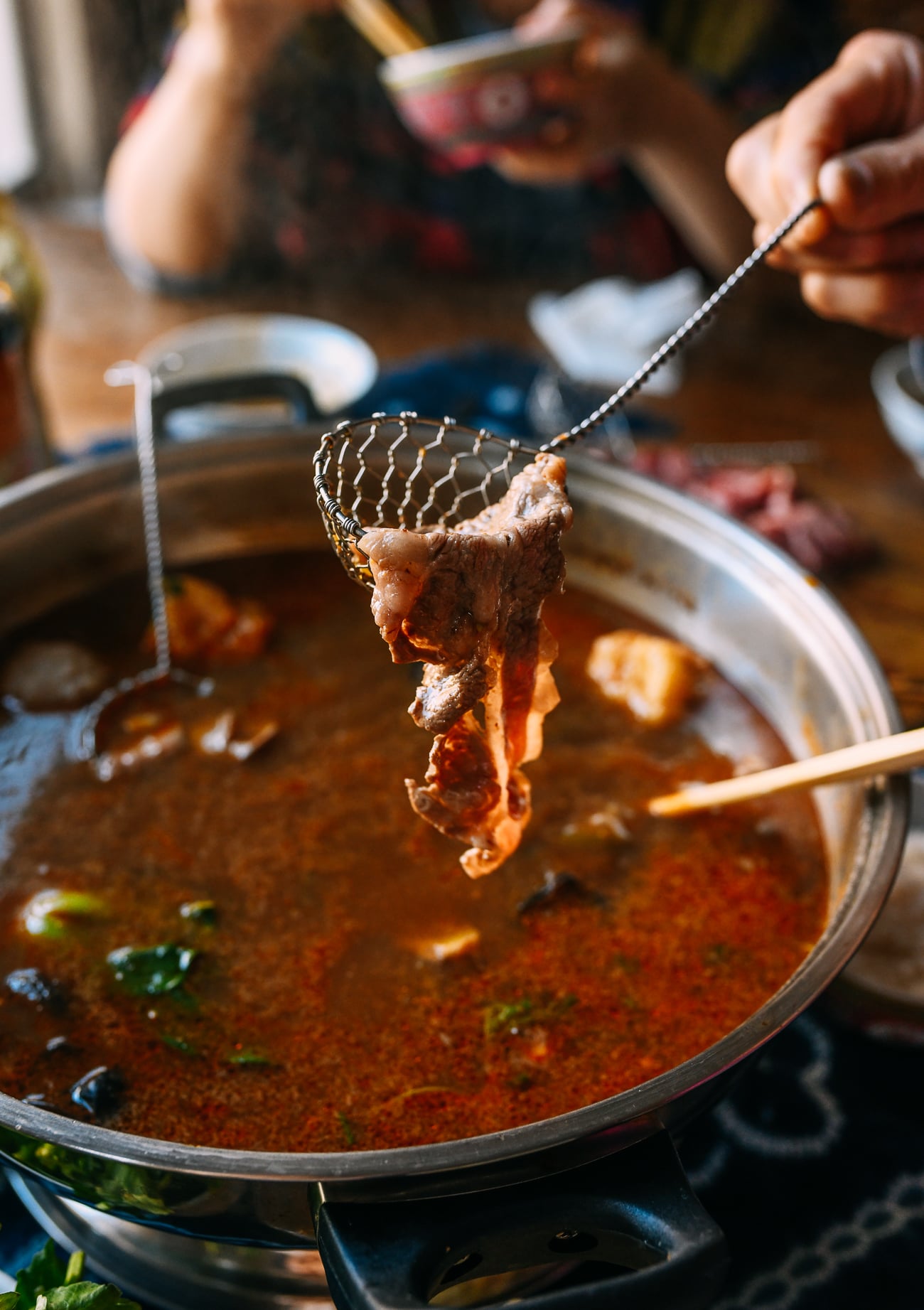 Lifting cooked beef out of hot pot