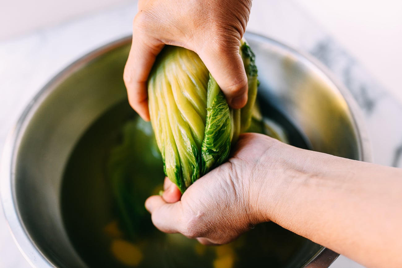 Squeezing mustard greens into smaller shape