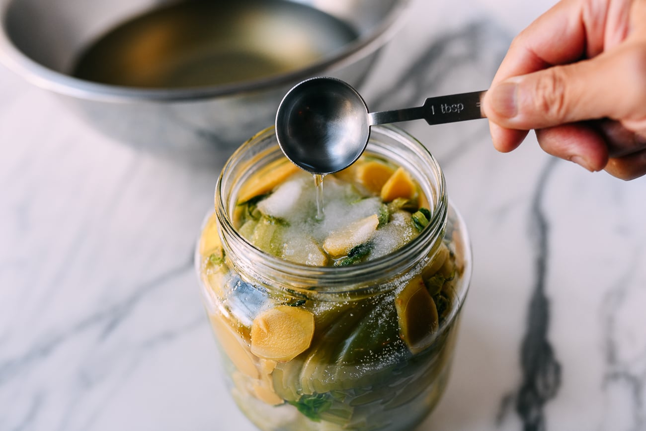 Adding white vinegar to pickling jar