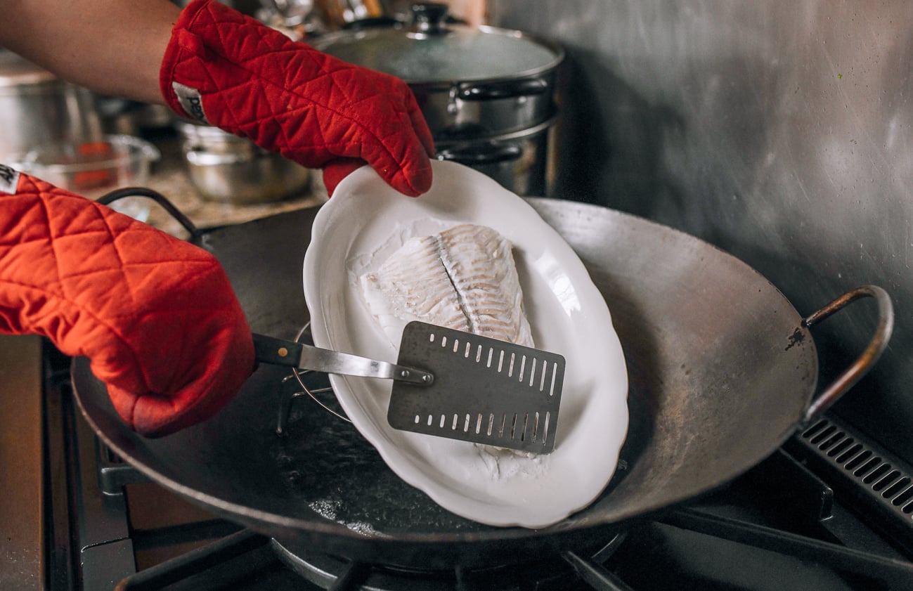 Draining liquid off plate of steamed fish