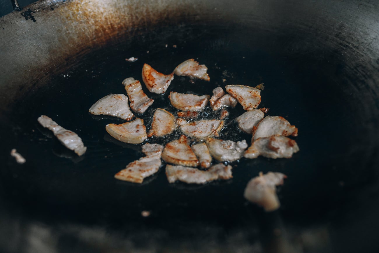 Browned pork belly slices in wok