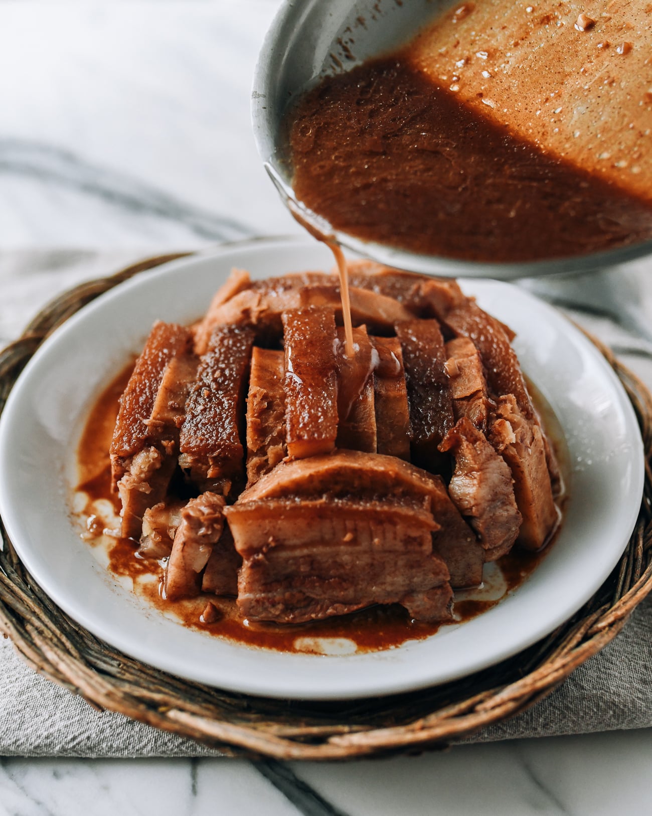 Pouring sauce over the top of pork belly and taro