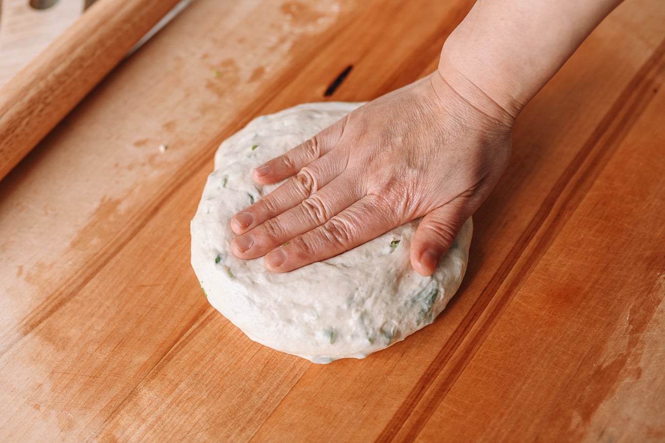 Pressing dough disc down with palm