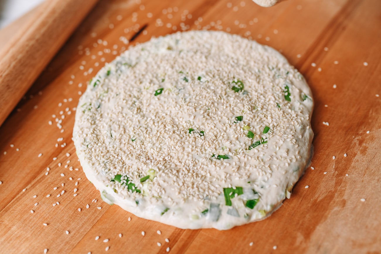 Sprinkling sesame seeds over dough