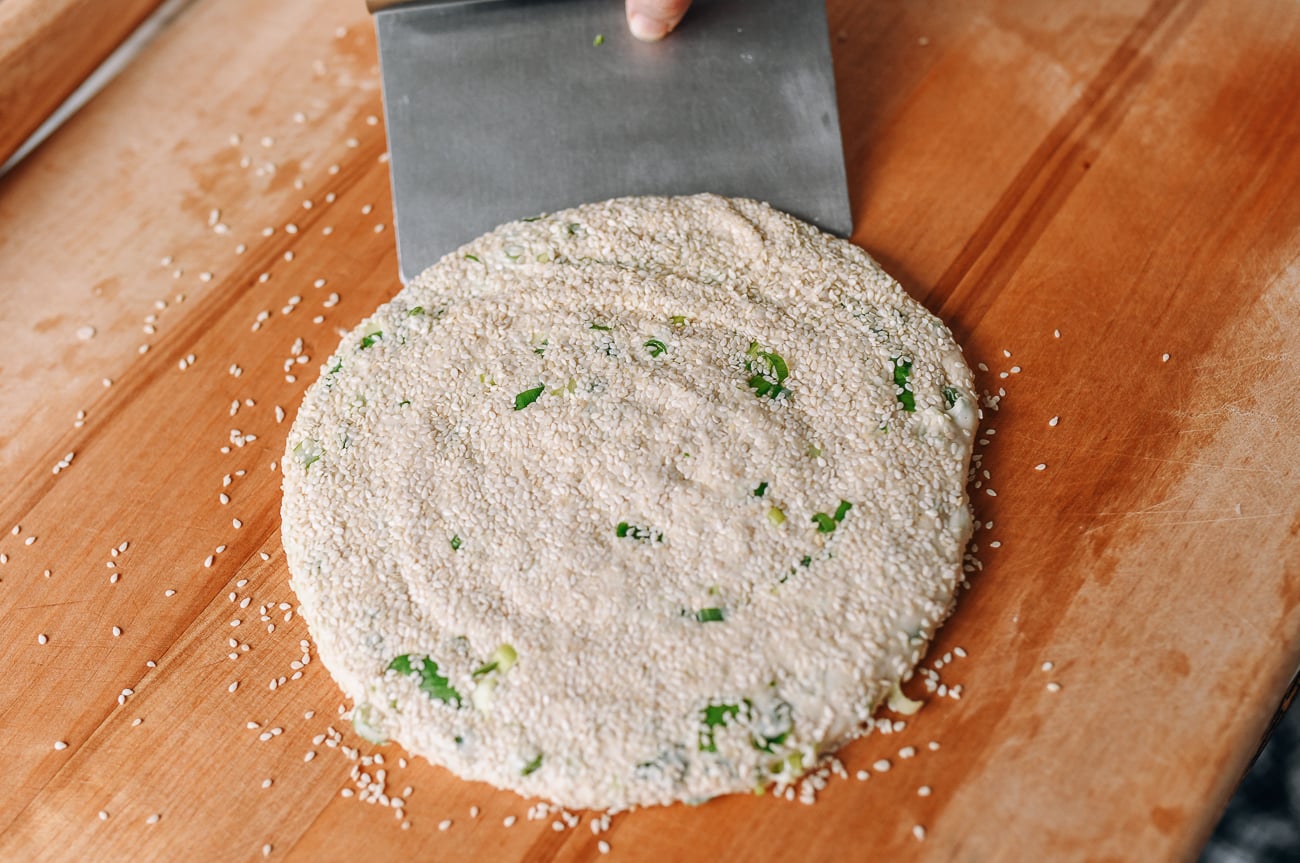 Using a bench scraper to flip dough over