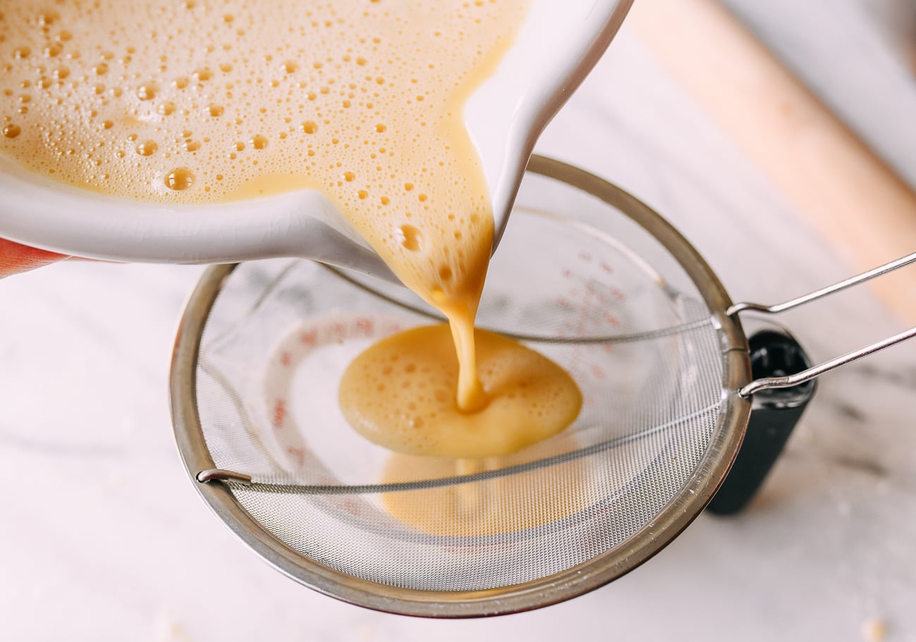 Straining custard into measuring cup