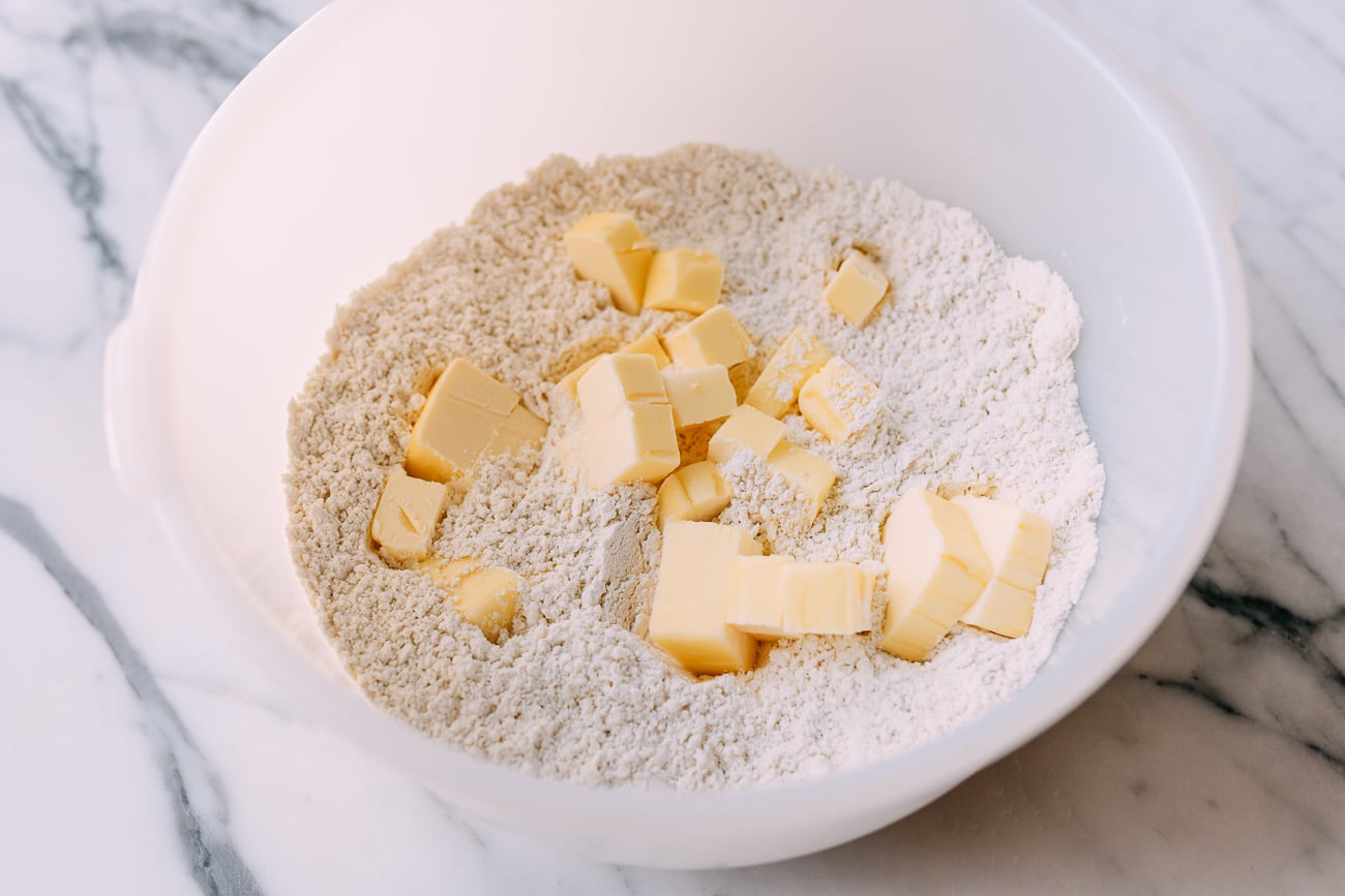 Butter cubes in bowl of flour and salt