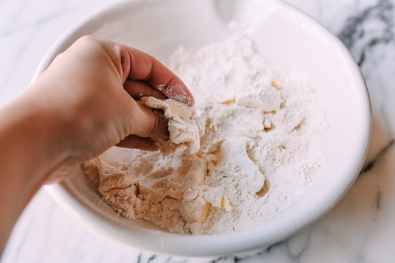 Breaking up butter in flour with hands