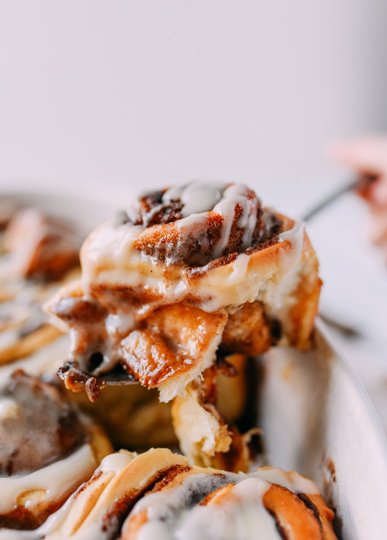 Removing fluffy cinnamon roll from baking dish
