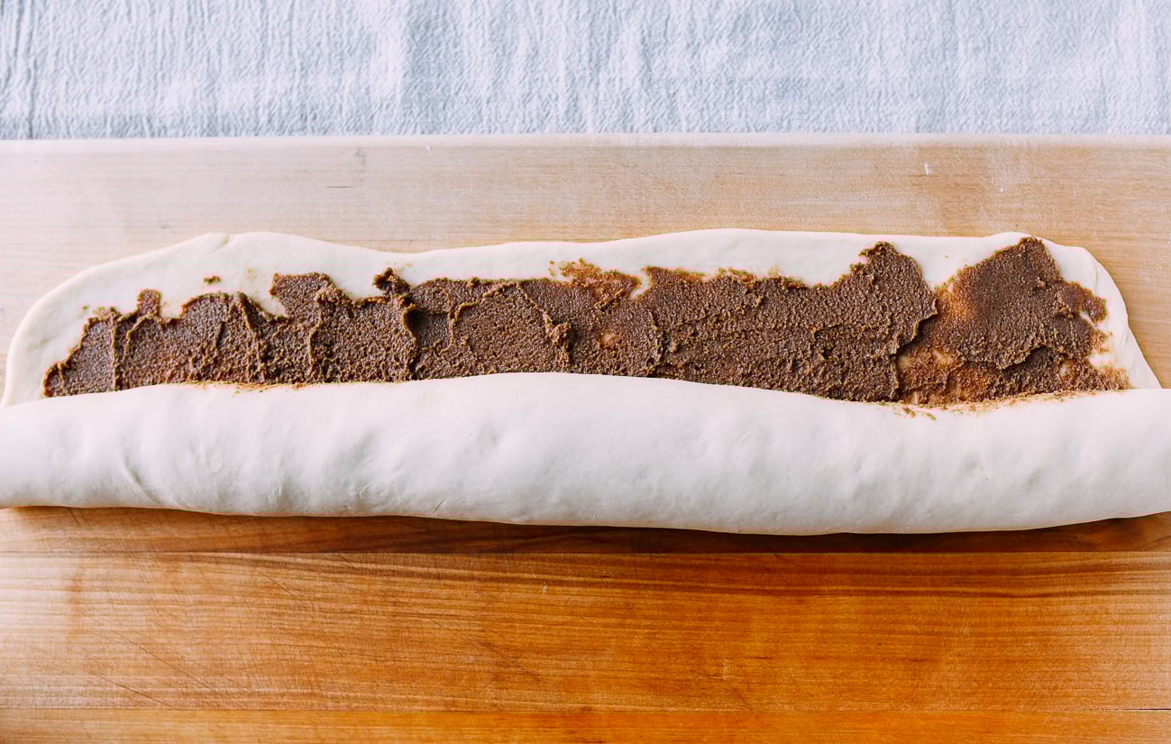 Rolling cinnamon filling into dough