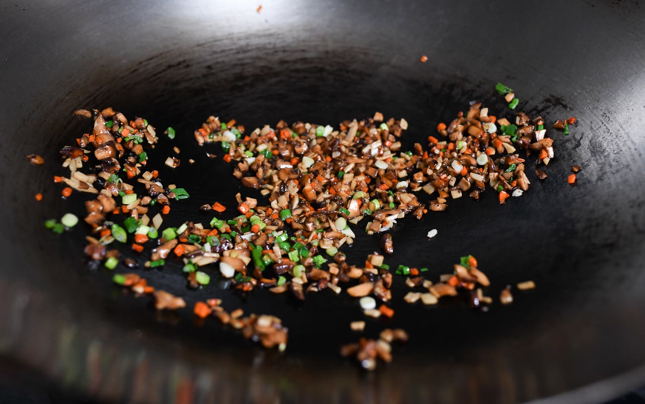 Stirring scallions into vegetable filling