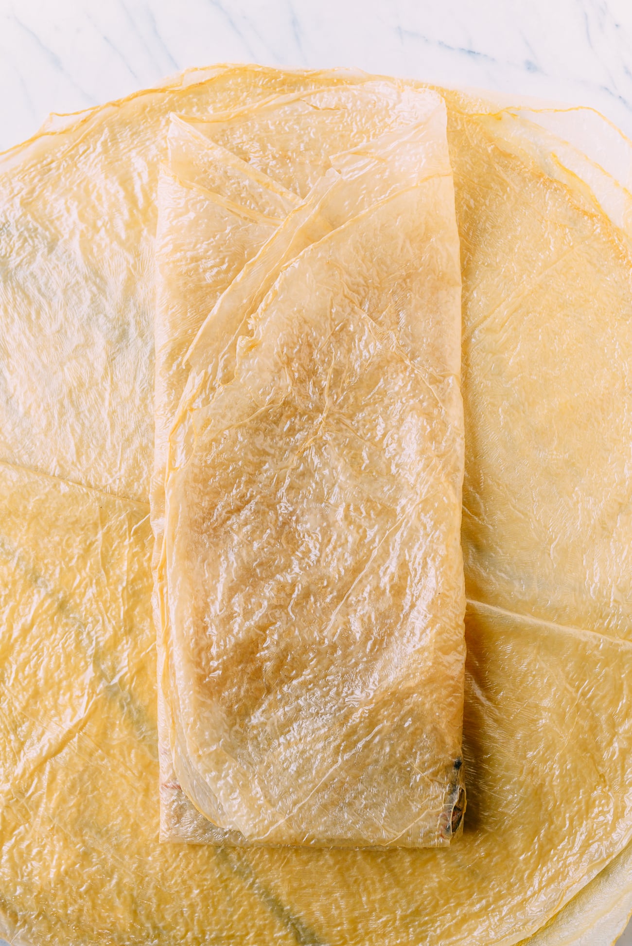 Folding sides of bean curd sheets over the middle