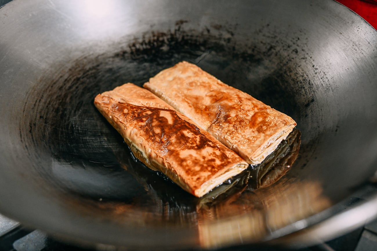 Browning bean curd rolls in wok