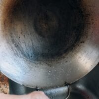 How to Wash a Wok - holding up a clean wok over the sink