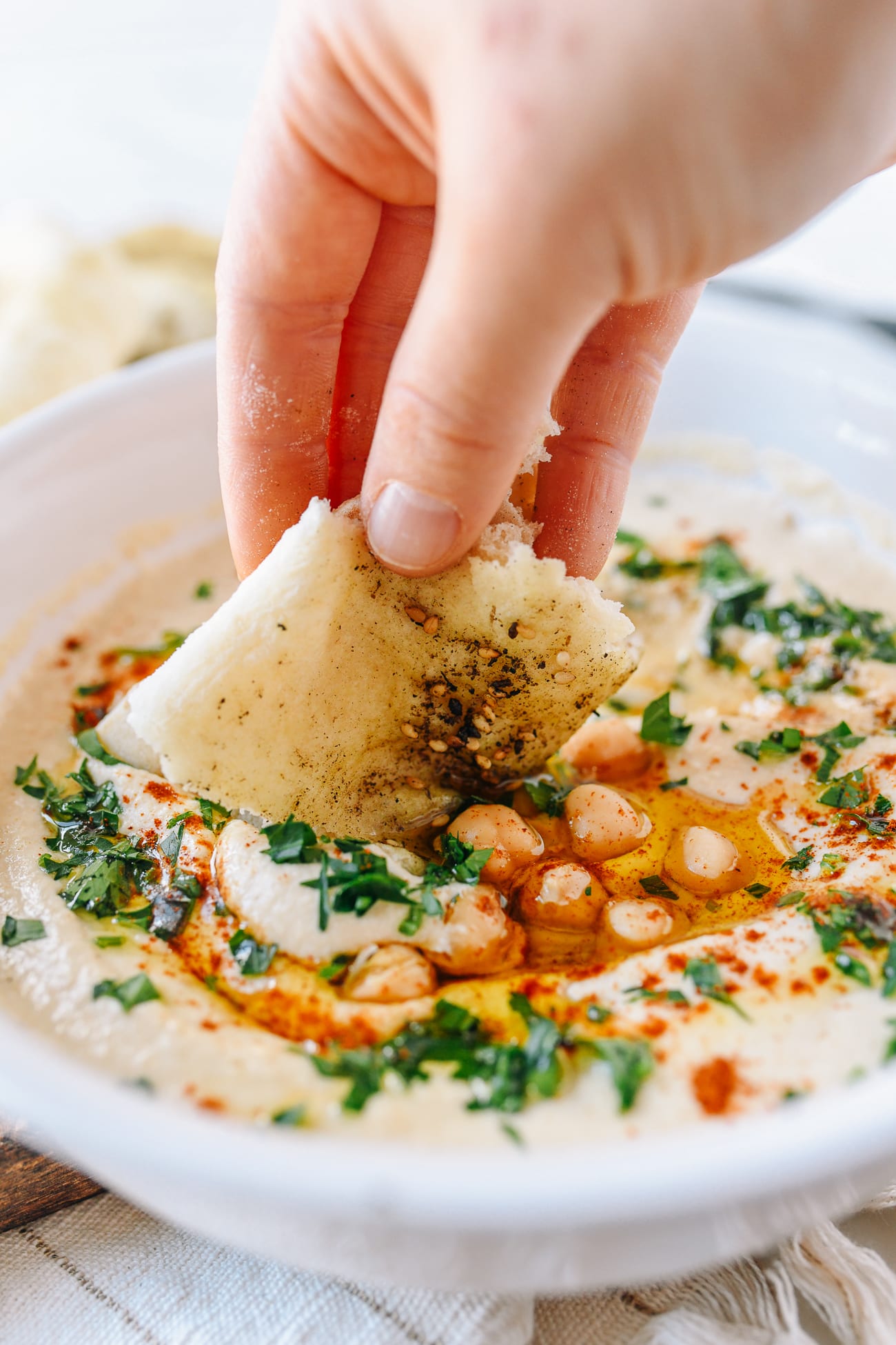 Dipping laffa bread into hummus